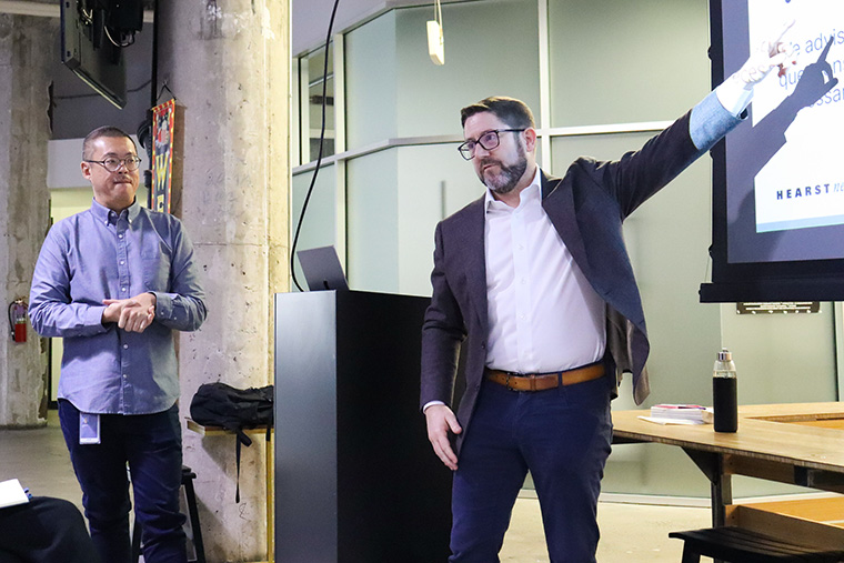 Hearst's Derrick Ho, editorial director/AI (left), and Tim O’Rourke, vice president/editorial innovation and AI strategy, talk with INMA study tour attendees.