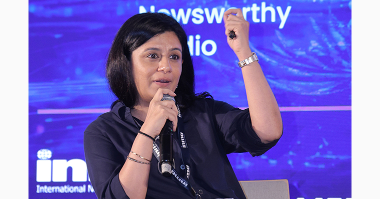 Anubha Bhonsle, founder of Newsworthy Studio, speaks with delegates at the conference.