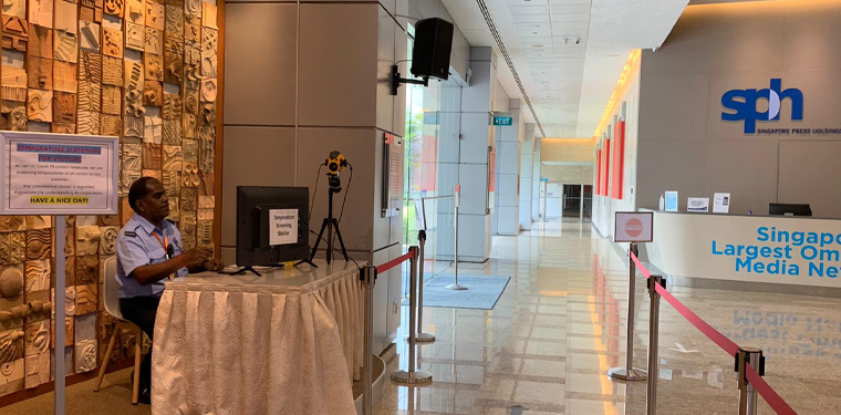A temperature screen station at the SPH main lobby. All visitors have to walk past the station before they are allowed to register at the reception area. The yellow camera mounted on the tripod in the picture is an infra-red camera. The security officer is there to monitor the heat signatures of all visitors and to prevent those who are running fevers proceed further.