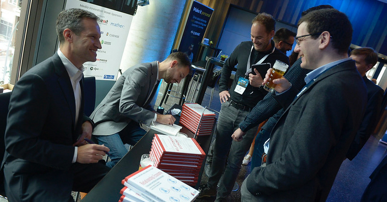Matt Lindsay and Matthijs van de Peppel sign copies of their book, "How to Succeed in the Relationship Economy," at the INMA symposium.