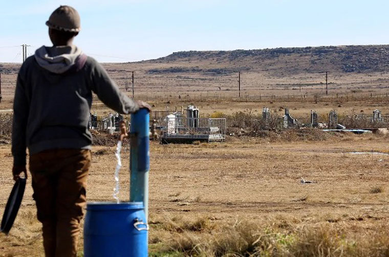 A young man from Phelandaba in Molteno fills up a barrel with water from a communal tap at the local graveyard. Credit: Bheki Radebe/I’solezwe lesiXhosa.