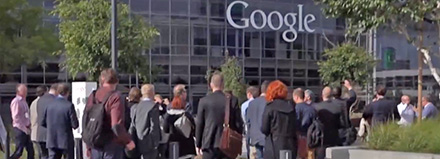 A group of people standing outside a Google office building.