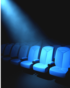 Spotlight shining down on blue theater audience seating.
