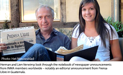 A man and his daughter looking through a notebook with dozens of newspapers.