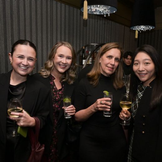 Four delegates with drinks in a dimly lit bar.