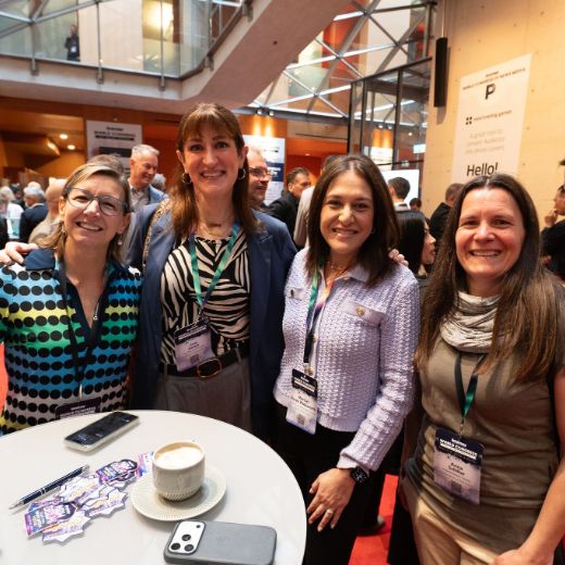 Four delegates around a cafe table on the conference floor.