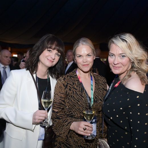 Three delegates with champagne at an evening reception.